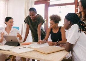 A diverse group of young people sitting around an office table having a business meeting